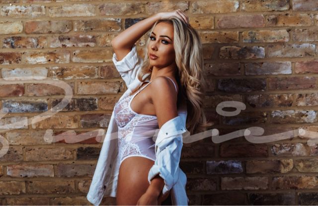 Fresca in white lingerie posing holding her hair up