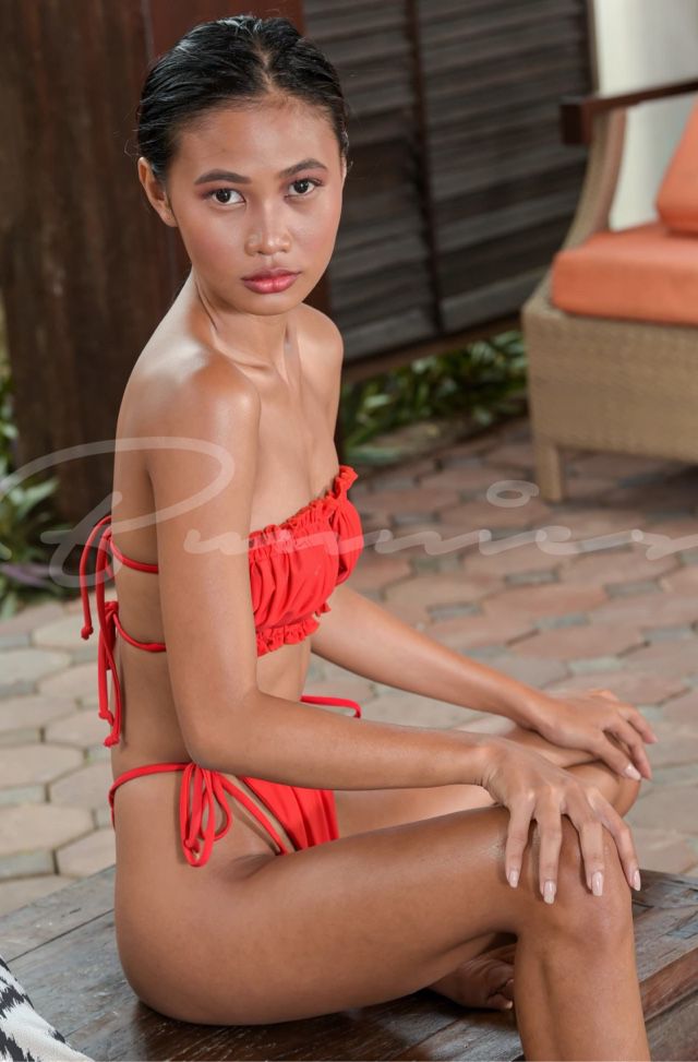 Ruby in red bathing suit sitting out by the pool
